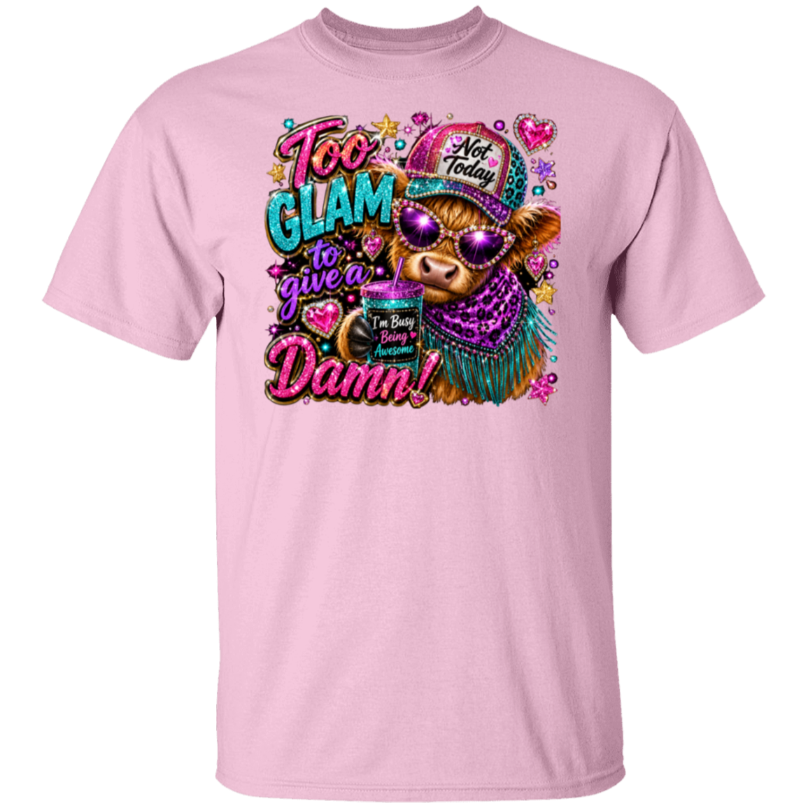 A light pink short-sleeve crewneck t-shirt featuring a colorful graphic print of a cow wearing a 'Not Today' hat and sunglasses, with the text 'Too Glam to give a Damn!' in a glittery font.