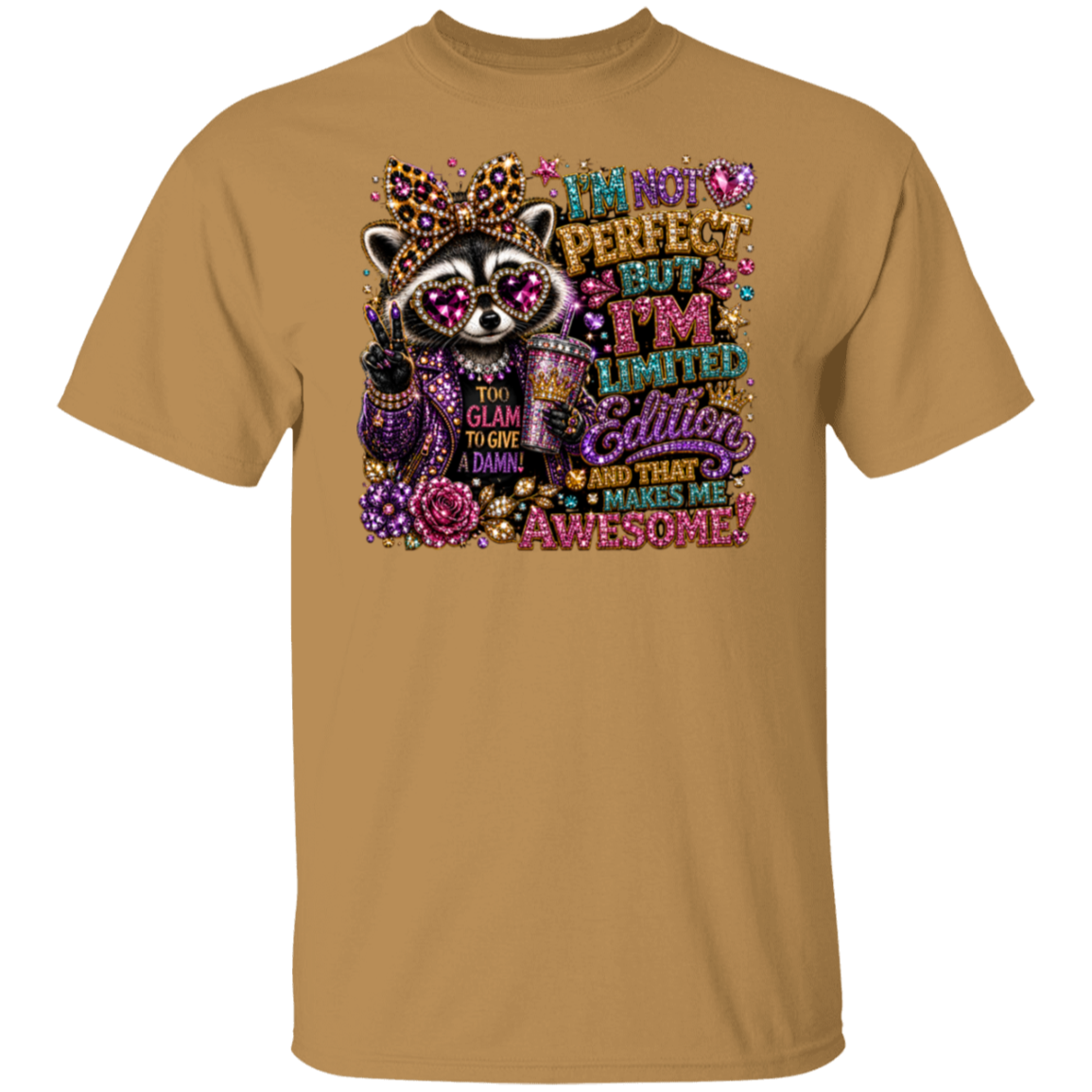 An old gold color crewneck t-shirt featuring a colorful graphic print of a raccoon wearing a leopard-print crown and sunglasses, surrounded by glittery text that reads 'I'm not perfect but I'm limited edition and that makes me awesome'.