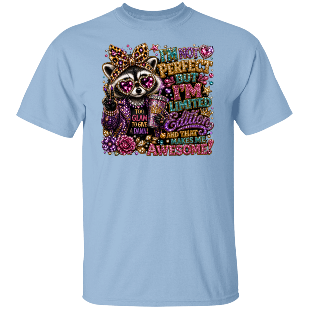 A light blue short-sleeve crewneck t-shirt featuring a colorful graphic of a raccoon wearing a crown and sunglasses, surrounded by glittery text that reads 'I'm not perfect but I'm limited edition glitter and that makes me awesome!'.