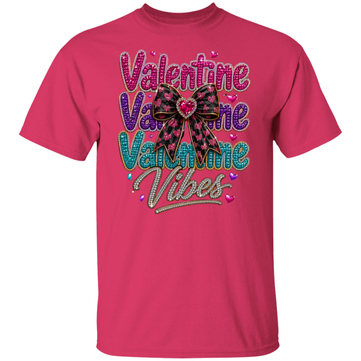 A heliconia short-sleeve t-shirt with a 'Valentine Vibes' graphic on the chest. The graphic features the word 'Valentine' repeated in wavy, glittery pink, purple, and teal fonts, accented with small hearts, and a large pink and black patterned bow in the center.
