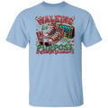 A light blue crewneck t-shirt featuring a large, colorful graphic print on the front. The graphic depicts a pair of glittery high-top sneakers, a drink with straws, sunglasses, and the text 'WALKING IN MY PURPOSE Built for Graduates' in a decorative, marquee-style font.